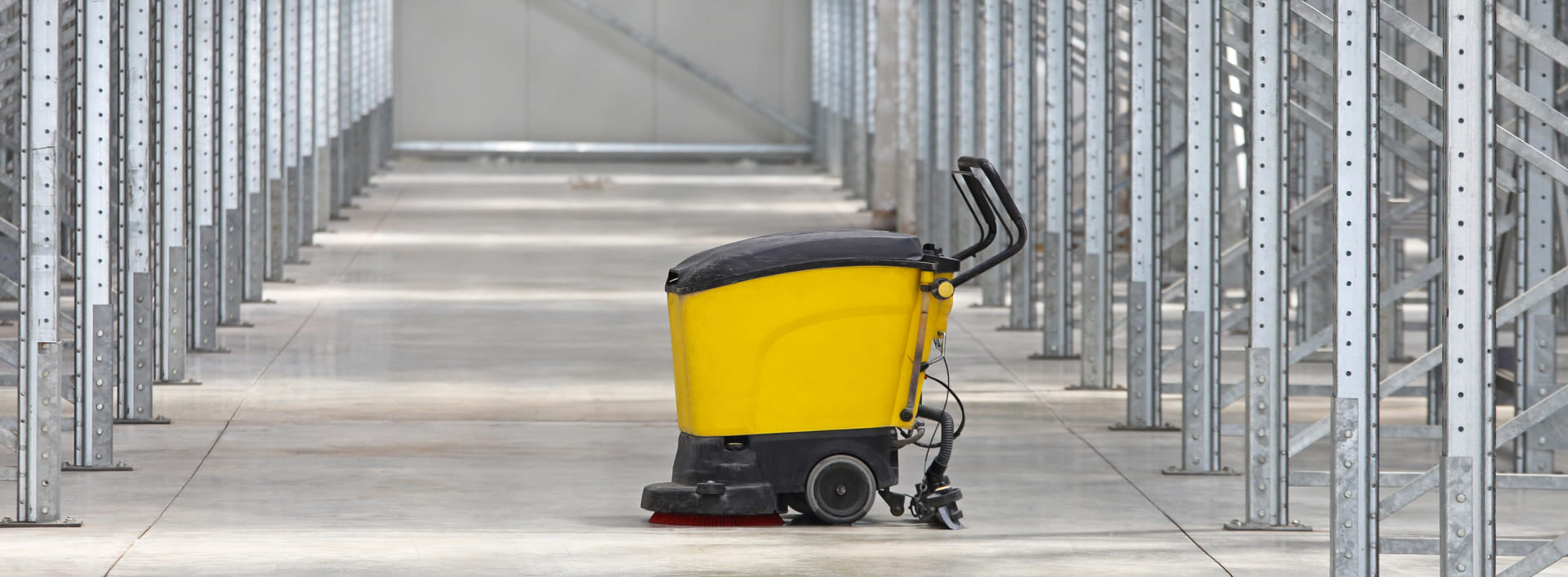 Nettoyage industriel des allées d'entrepôt avec une autolaveuse professionnelle.